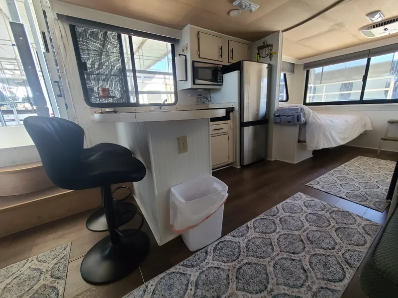 Slide: The Image of Interior of a 1993 Gibson SPORT SERIES houseboat with modern kitchen and cozy sleeping area. - 14