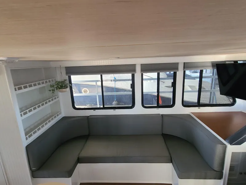 Slide: The Image of Interior of a 1993 Gibson SPORT SERIES boat with gray seating and large windows. - 8