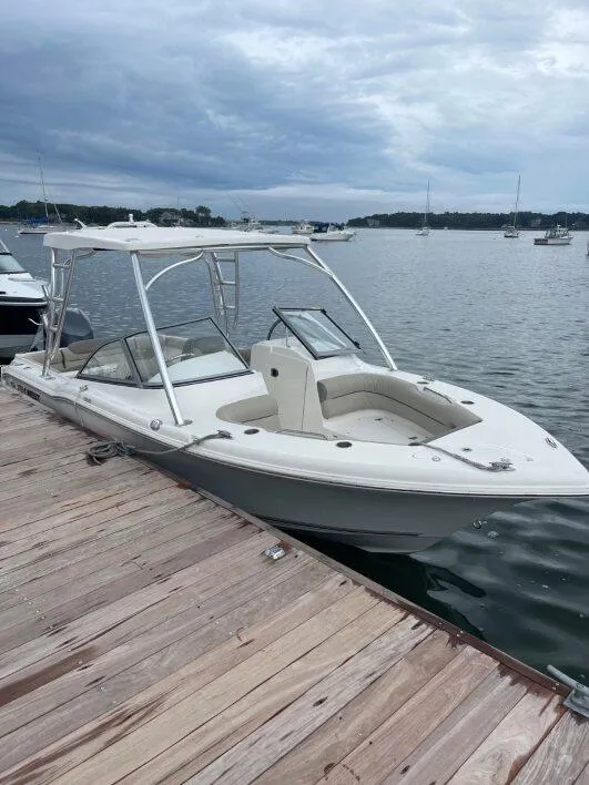 Slide: The Image of 2022 Key West 239 DFS boat docked on a wooden pier, with a cloudy sky backdrop. - 2