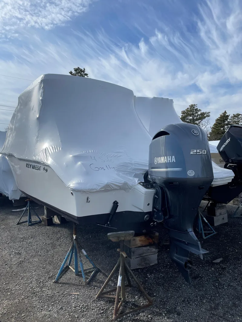 Slide: The Image of 2022 Key West 239 DFS boat with Yamaha 250 engine, covered and elevated on stands. - 4