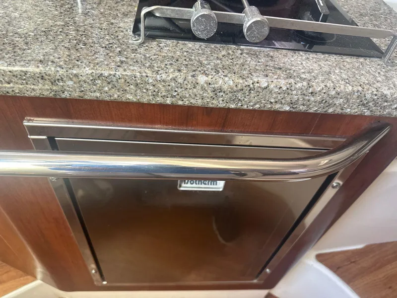 Slide: The Image of 2018 Robalo R305 Walkaround kitchen area with stainless steel appliances and granite countertop. - 14