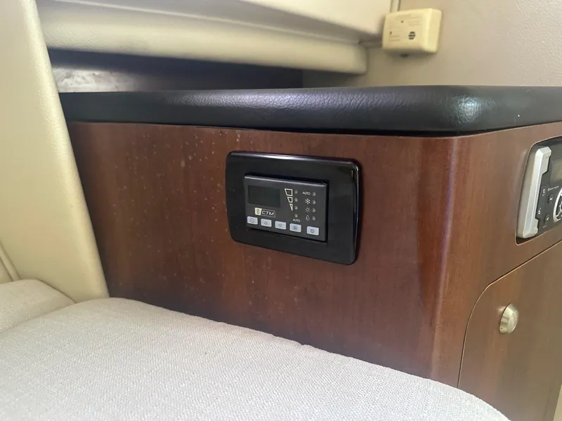 Slide: The Image of Control panel inside 2018 Robalo R305 Walkaround boat, featuring wood finish and cushioned seating. - 18