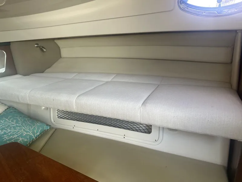 Slide: The Image of 2018 Robalo R305 Walkaround cabin interior with cushioned seating and window. - 19