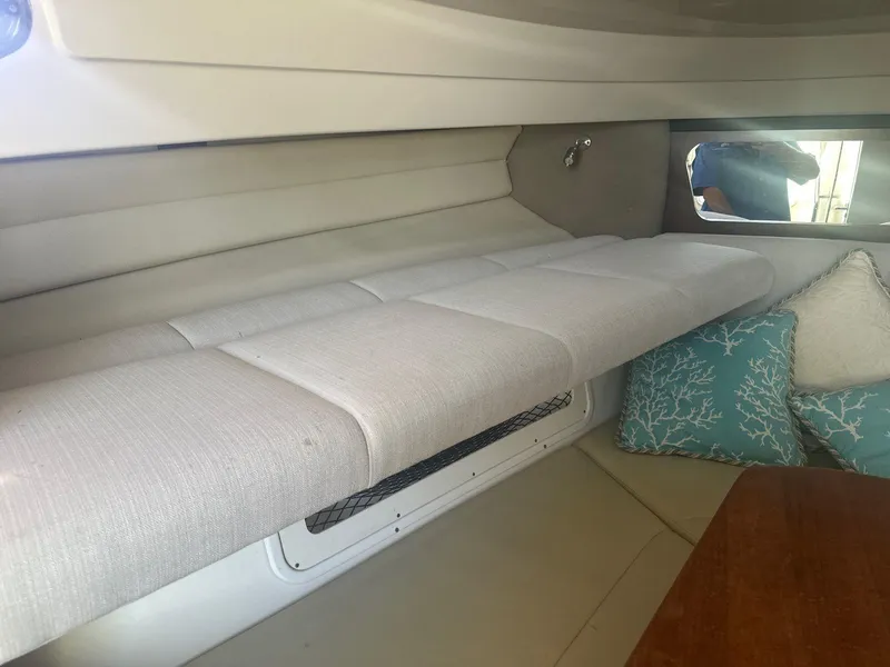 Slide: The Image of 2018 Robalo R305 Walkaround cabin interior with cushioned seating and decorative pillows. - 20