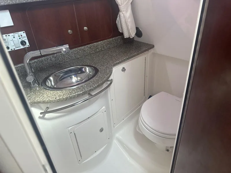 Slide: The Image of 2018 Robalo R305 Walkaround boat bathroom with sink, toilet, and storage cabinets. - 21