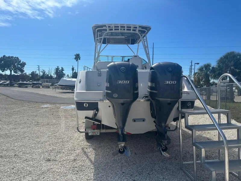 Slide: The Image of 2018 Robalo R305 Walkaround boat with twin Yamaha 300 engines, parked on gravel. - 22