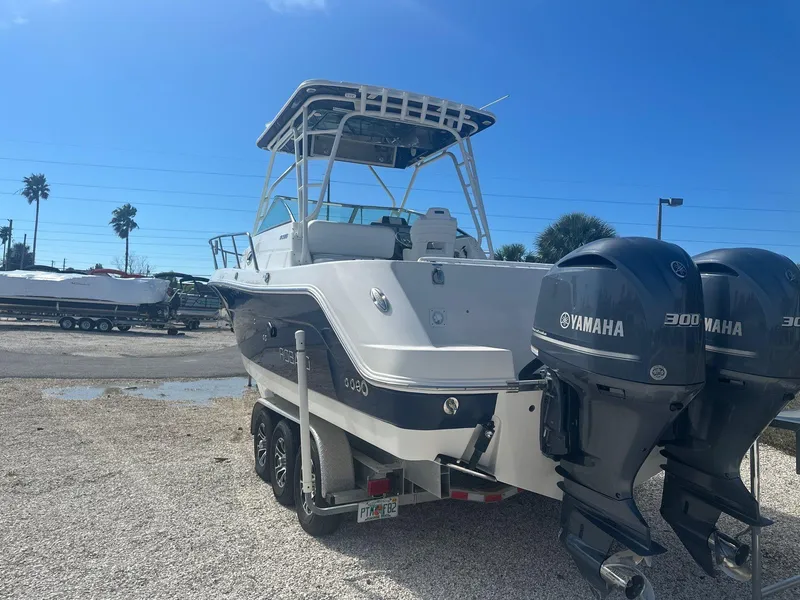 Slide: The Image of 2018 Robalo R305 Walkaround boat with dual Yamaha engines, parked on gravel. - 23