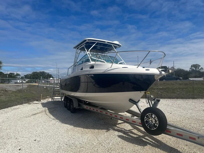 Slide: The Image of 2018 Robalo R305 Walkaround boat on trailer under a clear blue sky. - 3
