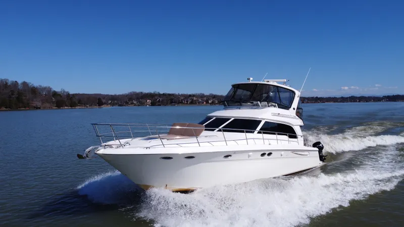 Slide: The Image of 2001 Sea Ray 480 Sedan Bridge yacht on calm water, showcasing sleek design and spacious deck. - 0