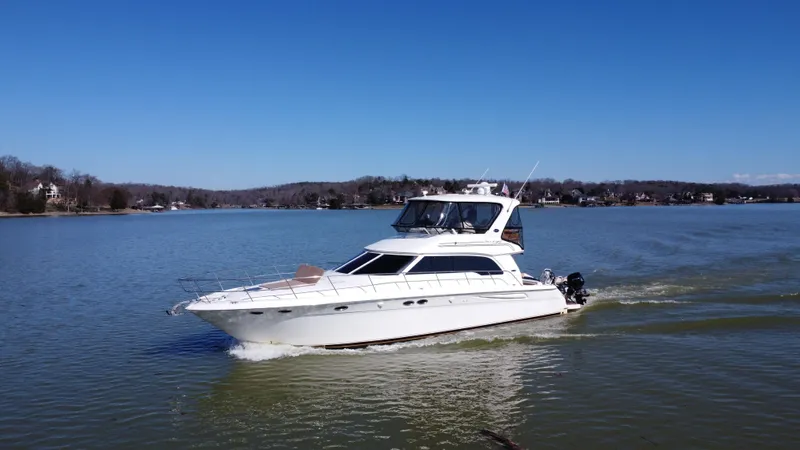 Slide: The Image of 2001 Sea Ray 480 Sedan Bridge cruising on a calm lake under clear blue skies. - 13