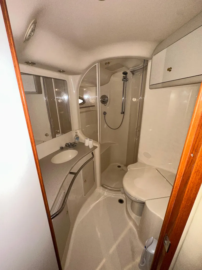Slide: The Image of 2001 Sea Ray 480 Sedan Bridge bathroom with shower, sink, and storage cabinets. - 16