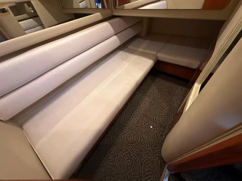 Slide: The Image of Interior seating area of 2001 Sea Ray 480 Sedan Bridge with beige upholstery and patterned carpet. - 19