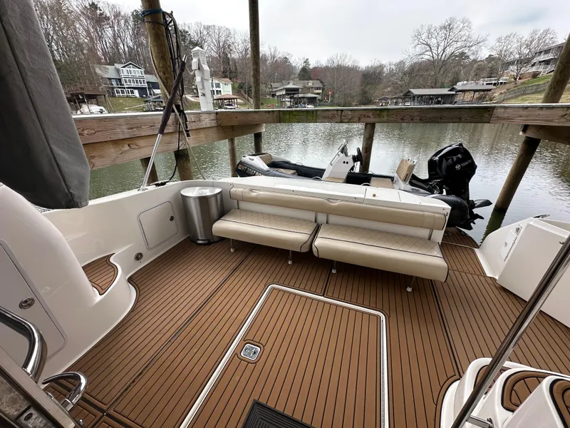 Slide: The Image of 2001 Sea Ray 480 Sedan Bridge yacht with spacious deck and seating, docked by a serene lake. - 21