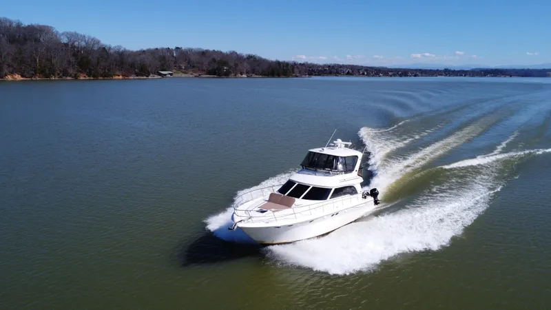 Slide: The Image of 2001 Sea Ray 480 Sedan Bridge cruising on a serene lake. - 4