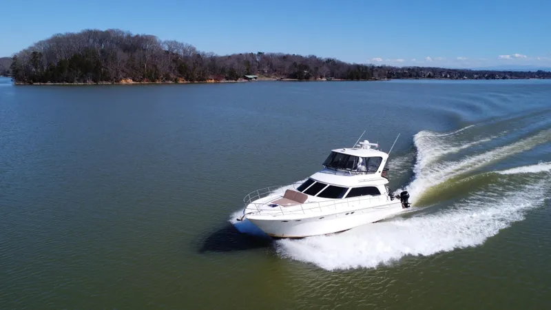 Slide: The Image of 2001 Sea Ray 480 Sedan Bridge cruising on a serene lake. - 8
