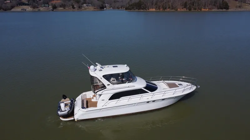 Slide: The Image of 2001 Sea Ray 480 Sedan Bridge yacht on calm lake waters. - 9