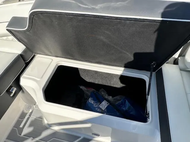Slide: The Image of 2025 Regal LS4 Surf boat storage compartment open, showing interior space. - 17