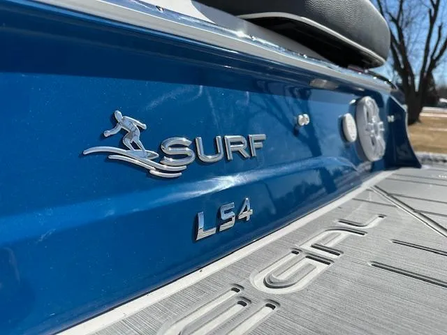 Slide: The Image of 2025 Regal LS4 Surf boat, blue exterior with surf logo detail. - 2