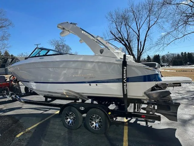Slide: The Image of 2025 Regal LS4 Surf boat on trailer, parked outdoors, sunny day. - 3