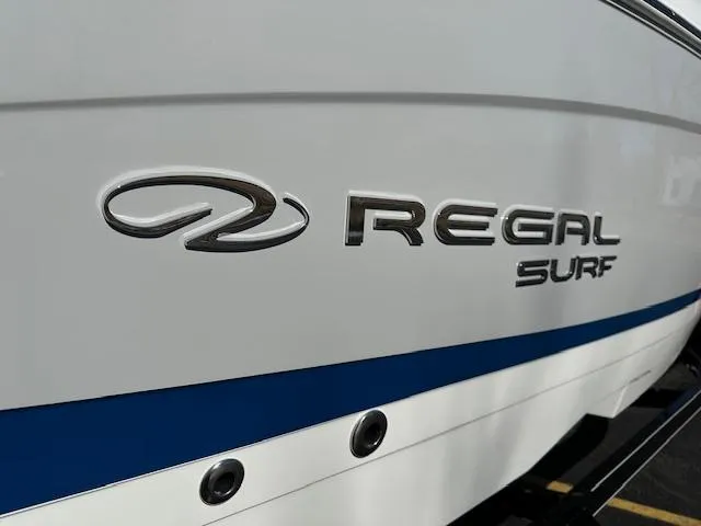 Slide: The Image of 2025 Regal LS4 Surf boat logo on white hull with blue stripe. - 4