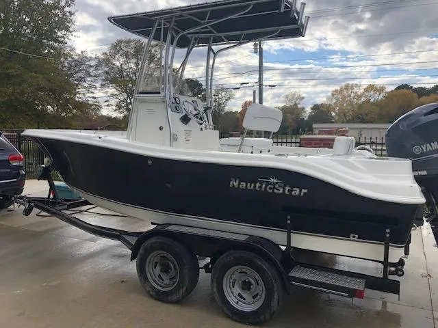 Slide: The Image of 2014 NauticStar 1900 XS boat on trailer, black hull, overcast sky. - 10