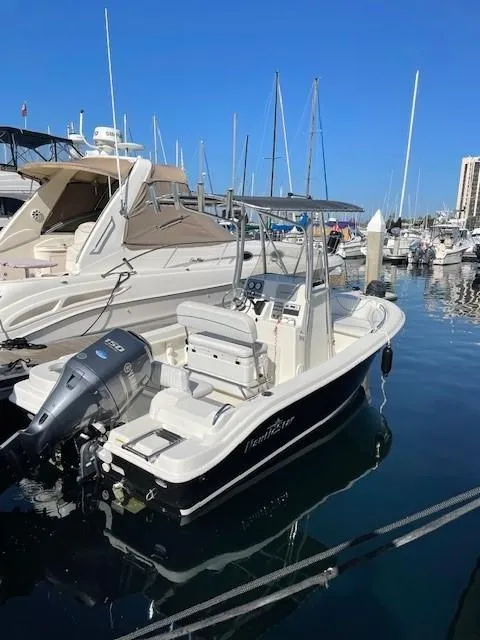 Slide: The Image of 2014 NauticStar 1900 XS boat docked in marina, surrounded by other vessels. - 16