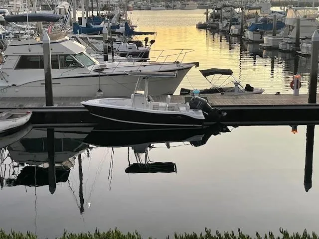 Slide: The Image of 2014 NauticStar 1900 XS boat docked in a serene marina at sunset. - 8