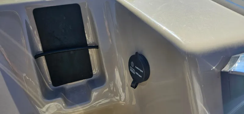 Slide: The Image of 2023 Sun Tracker SF-22XP3 boat interior detail with storage compartment and power outlet. - 16