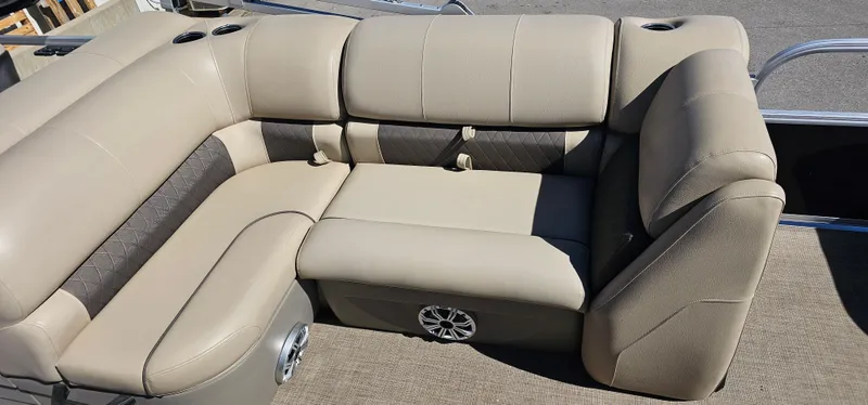 Slide: The Image of 2023 Sun Tracker SF-22XP3 boat interior with beige seating and built-in speaker. - 19