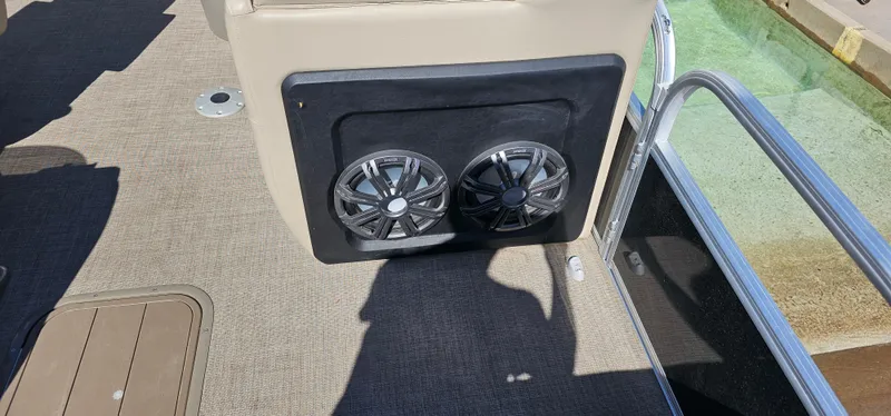 Slide: The Image of 2023 Sun Tracker SF-22XP3 boat interior with dual speakers and carpeted flooring. - 8
