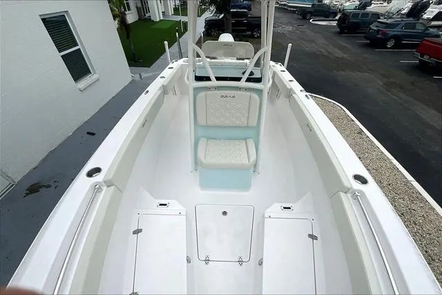 Slide: The Image of 2025 Aquasport 2200 Center Console boat, white interior, docked near a building. - 19