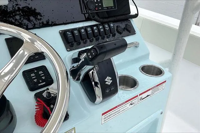 Slide: The Image of 2025 Aquasport 2200 Center Console boat dashboard with steering wheel and controls. - 24