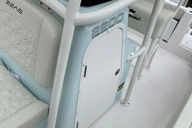 Slide: The Image of 2025 Aquasport 2200 Center Console boat interior with white seating and storage compartment. - 30