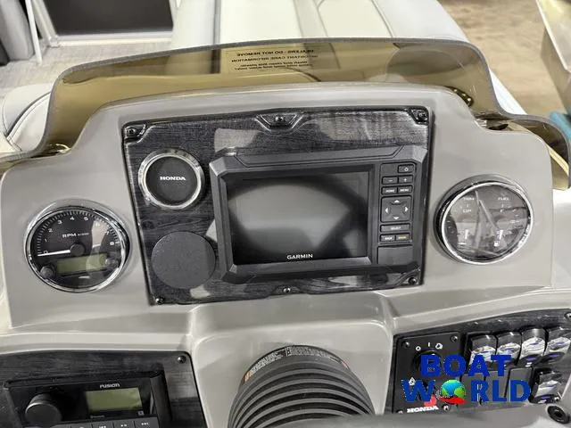 Slide: The Image of 2025 Tahoe Sport 23' Fish & Cruise dashboard with Garmin display and Honda controls. - 15