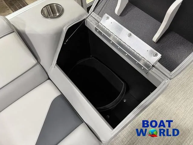 Slide: The Image of 2025 Tahoe Sport 23' Fish & Cruise boat storage compartment with cup holder, Boat World logo. - 26