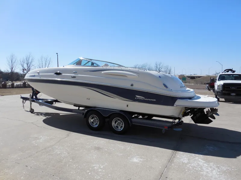 Slide: The Image of 2003 Chaparral Sunesta 243 boat on trailer, parked outdoors under clear blue sky. - 5