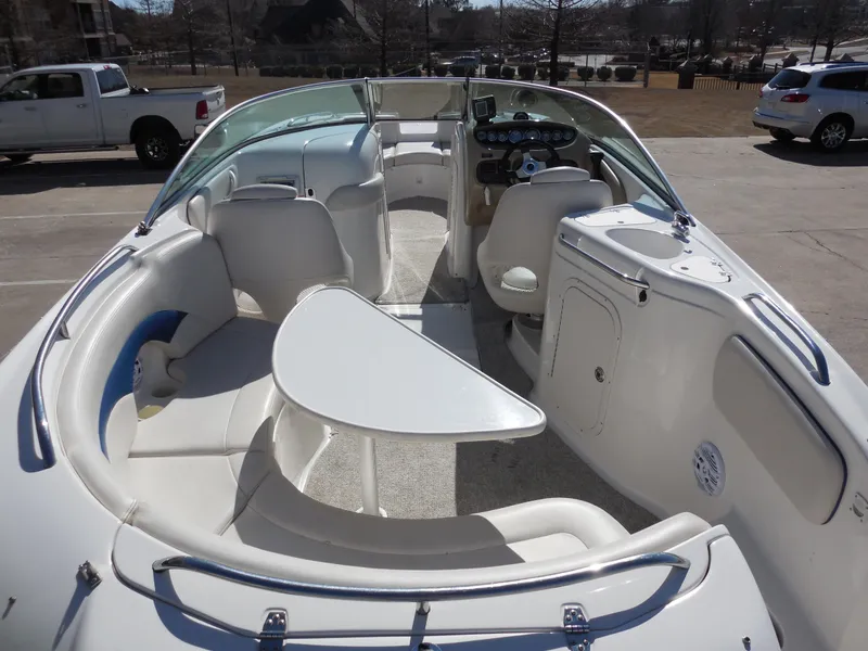 Slide: The Image of 2003 Chaparral Sunesta 243 boat interior with seating and table, parked outdoors. - 7