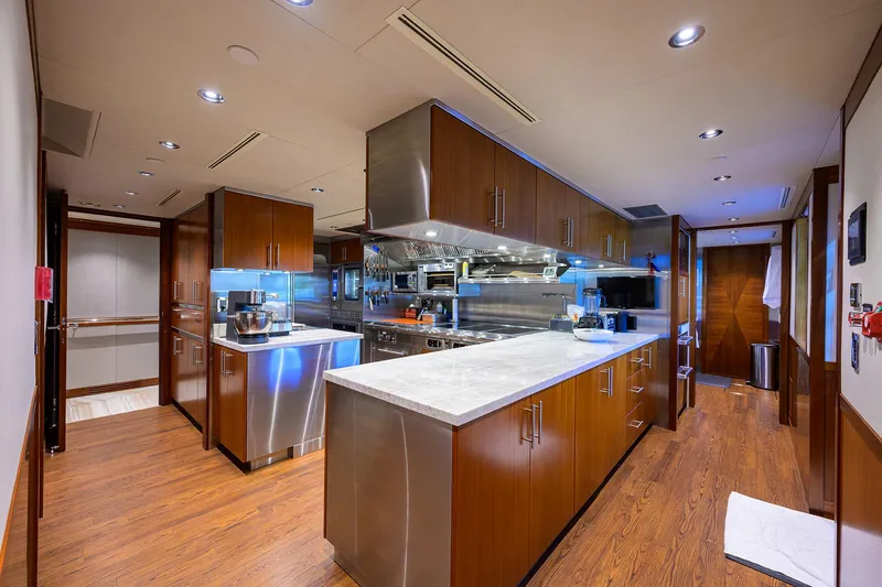 Slide: The Image of Luxurious kitchen interior on a 2020 Westport Motor Yacht, featuring modern appliances and wood finishes. - 17