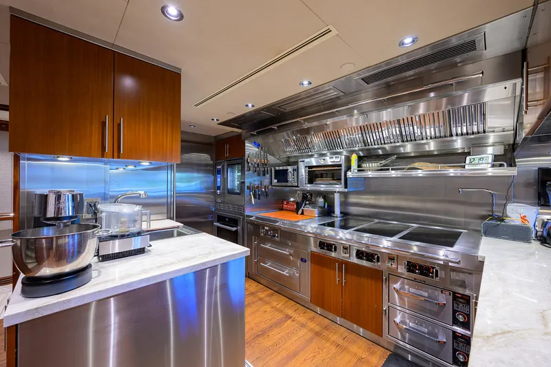 Slide: The Image of Luxurious Westport Motor Yacht 2020 kitchen with modern appliances and sleek wooden cabinetry. - 18