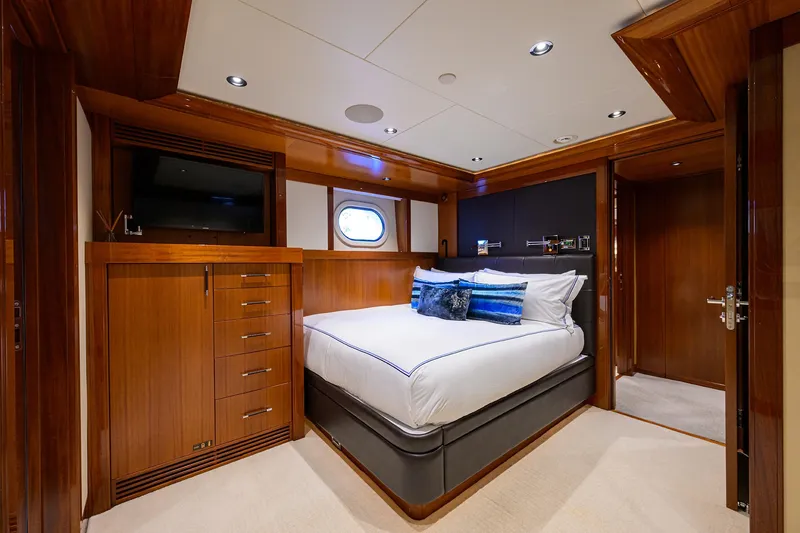 Slide: The Image of Luxurious 2020 Westport Motor Yacht bedroom with elegant wood finishes and modern amenities. - 26