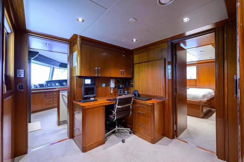 Slide: The Image of Luxurious Westport Motor Yacht 2020 interior with wood cabinetry, office space, and bedroom. - 32
