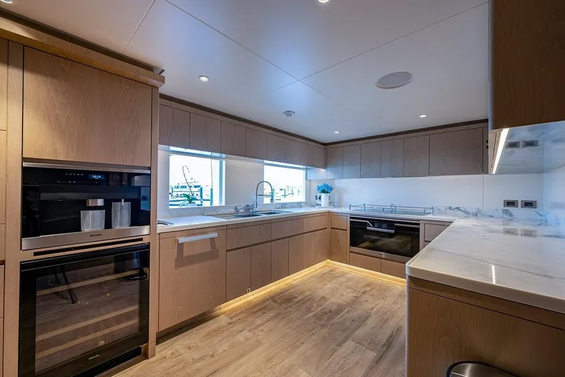Slide: The Image of Modern kitchen interior on 2020 Majesty motor yacht, featuring sleek wood cabinetry and marble countertops. - 9