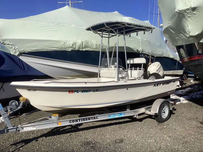 Slide: The Image of 2002 Key West 1720 boat on trailer, parked outdoors, covered boats in background. - 0