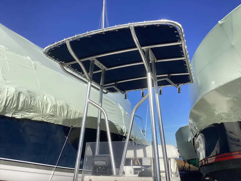 Slide: The Image of 2002 Key West 1720 boat with T-top, docked and covered, under clear blue sky. - 11