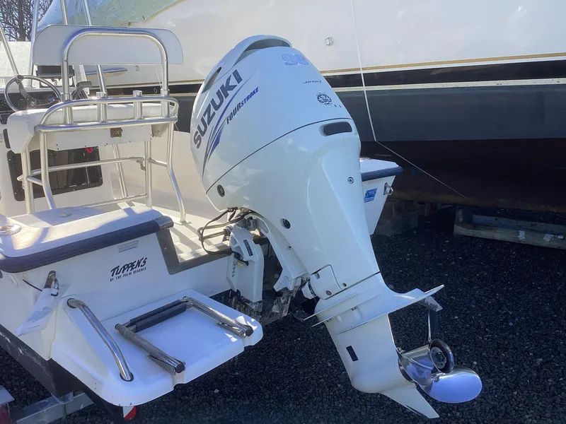Slide: The Image of 2002 Key West 1720 boat with Suzuki outboard motor, parked on gravel. - 5