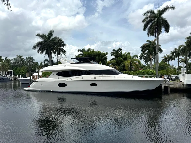 Slide: The Image of 2008 Lazzara Motor Yacht docked by palm trees under a cloudy sky. - 0