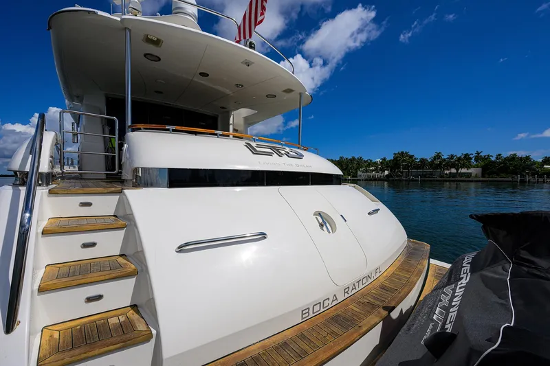 Slide: The Image of 2008 Lazzara Motor Yacht docked, rear view with steps, blue sky, and water backdrop. - 1