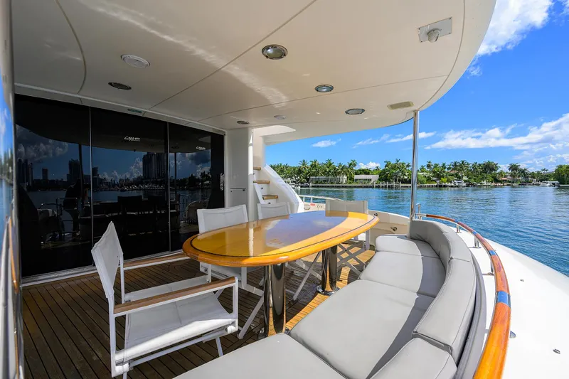 Slide: The Image of Luxurious 2008 Lazzara Motor Yacht deck with seating, table, and scenic waterfront view. - 2
