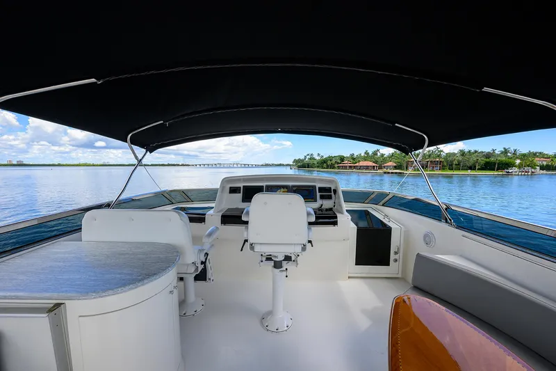 Slide: The Image of 2008 Lazzara Motor Yacht interior with helm, seating, and canopy on a serene waterway. - 42