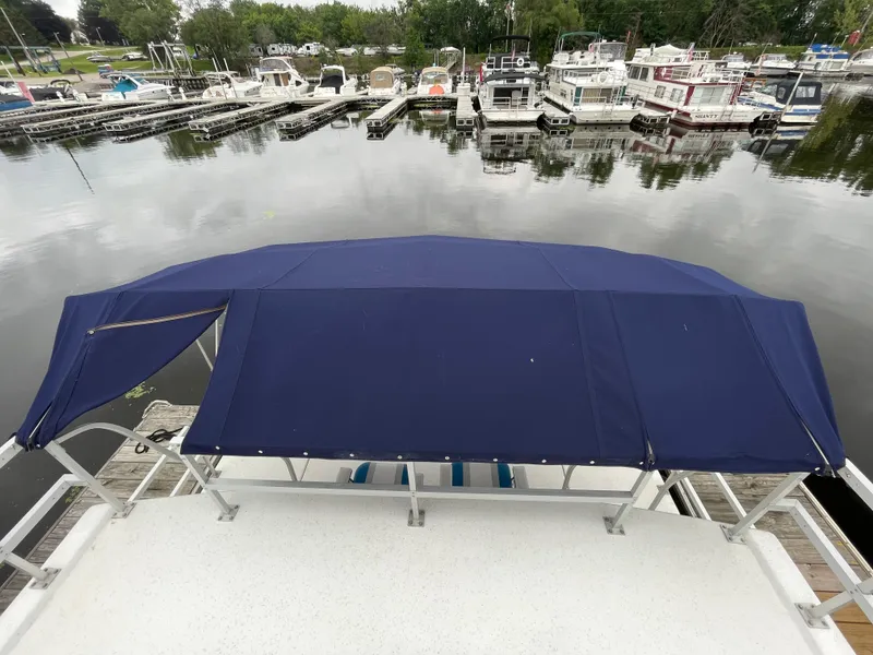 Slide: The Image of 2003 Gibson 50 Classic boat with blue canopy docked at marina. - 13